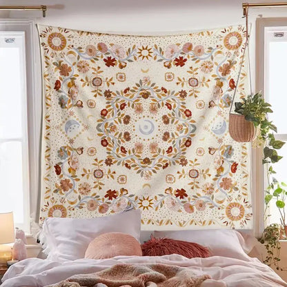 A cream-colored decorbites celestial floral moon phase tapestry with rust gold and muted blue hangs above a bed