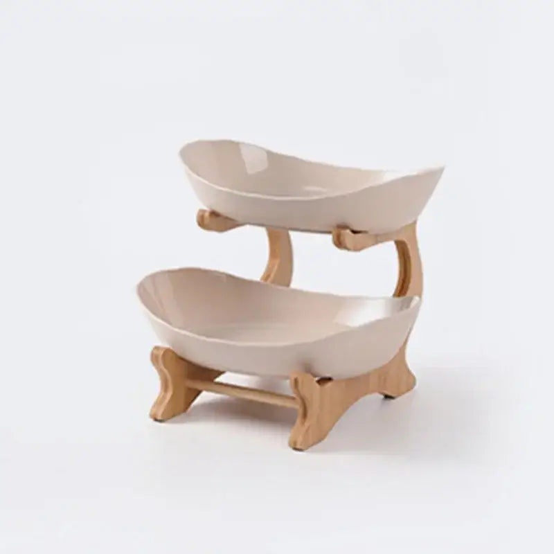 Beige ceramic two-tier serving stand with light wood-tone bamboo legs as part of a ceramic and teal table plates set for dining