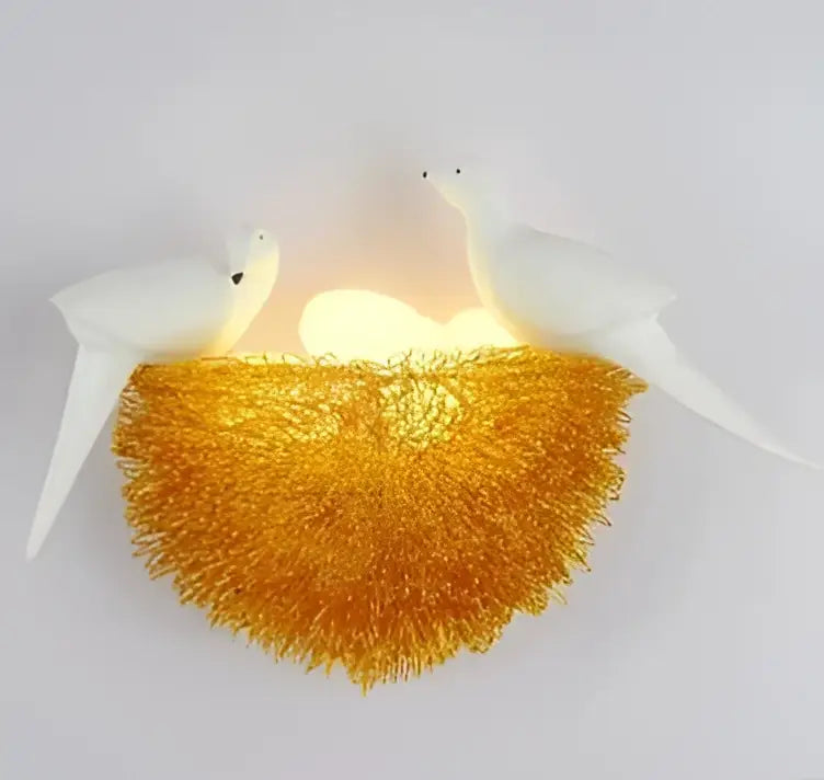 Glowing golden ceramic bird and nest led wall lamp with two white birds ideal for bedroom sconce lighting