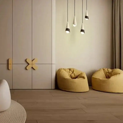 Three conical ceramic ice cream pendant lights with textured white bodies and black patterned bases with led bulbs