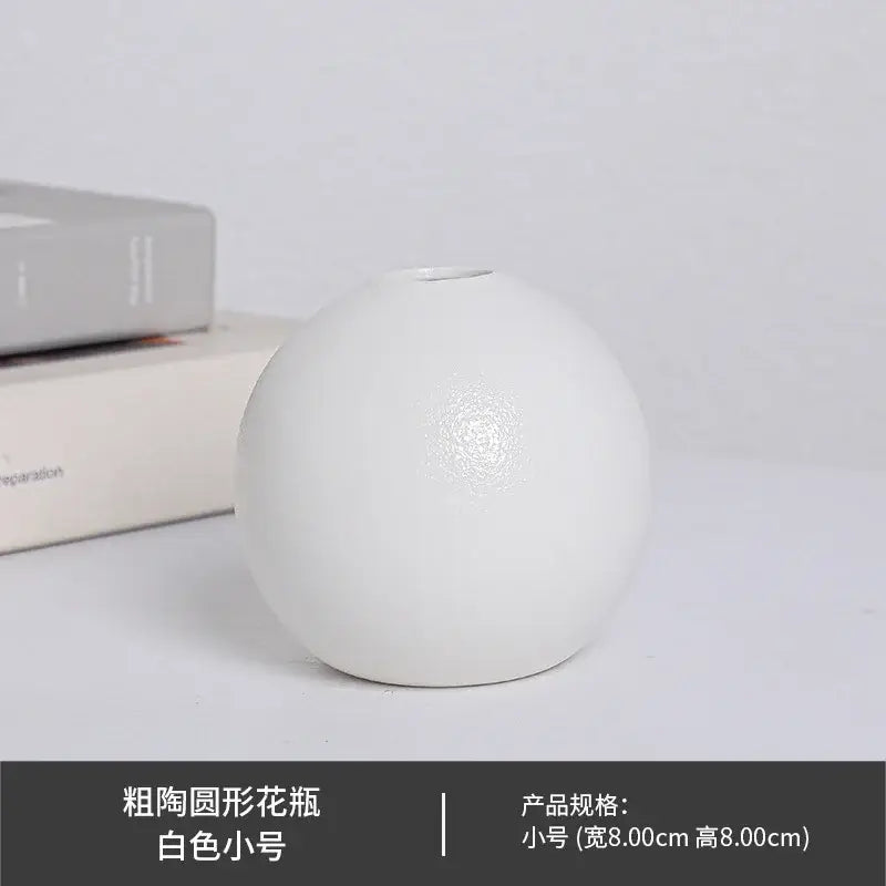 Minimalist ceramic round vase black white with a bulbous shape and subtle textured detailing on a white surface