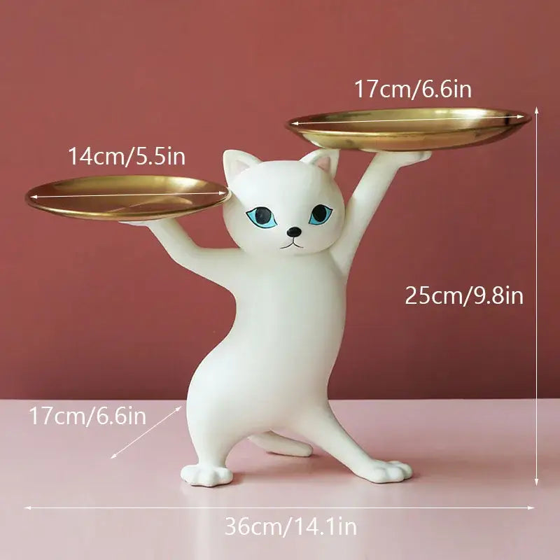 White ceramic cat figurine with blue eyes balancing gold plates in a beige cat figurines storage tray for living room decor