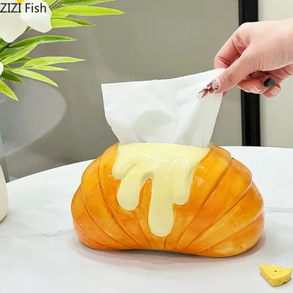 Golden ceramic tissue box shaped like a croissant with yellow icing drip decorbites croissant ceramic bedroom decor