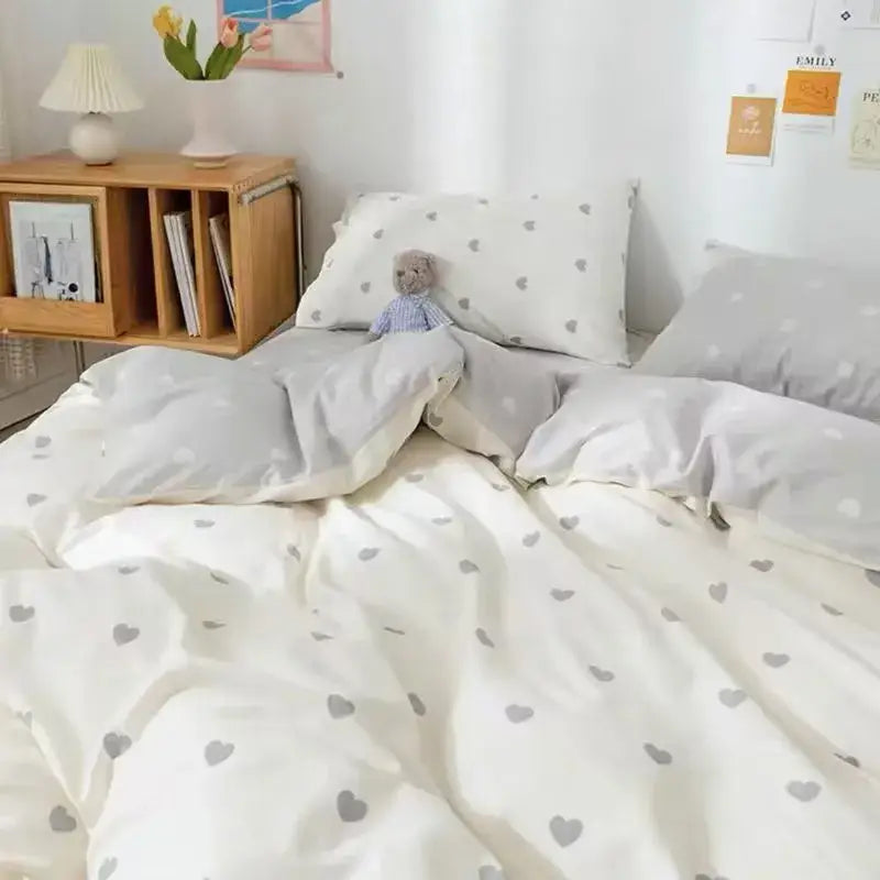 Soft white duvet cover set with gray heart patterns paired with cozy stuffed toy in checkerboard black and beige satin bedding