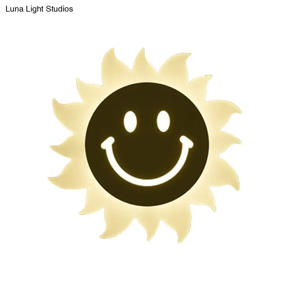 A warm yellow led wall sconce shaped like a smiling sun with radiant rays for bedroom lighting