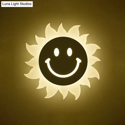 Cheerful white smiling sun led wall sconce featuring a warm glowing sun shape with black face and radiant white rays