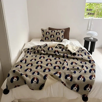 Soft beige rollie loop fleece blanket with playful basset hound faces and pom-poms for cozy bedroom use