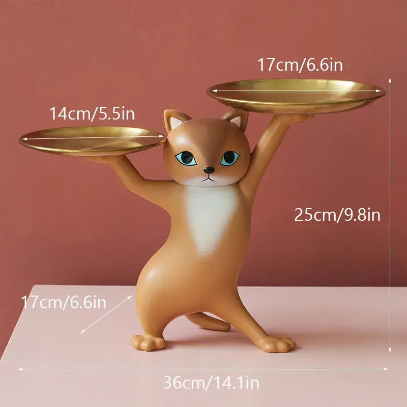 A chic cream and gold decorbites cat resin tray featuring a tan cat figurine with blue eyes balancing golden plates
