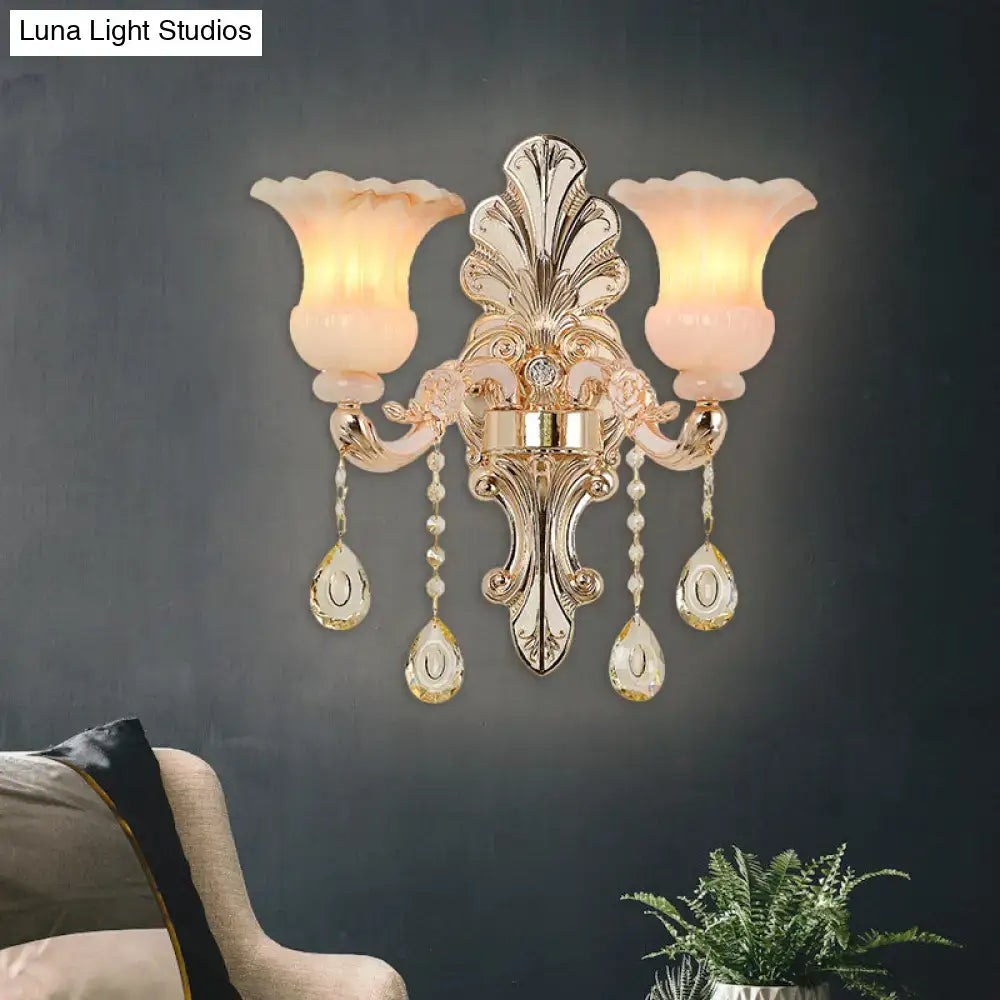 Chic gold wall lamp with pink crystal glass shades and dangling teardrop pendants for bedroom decor