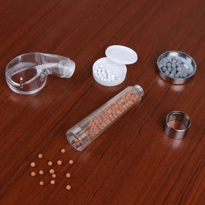 Clear plastic shower filter cartridge with tan and white ceramic beads for chrome anion spa shower head decorbites anion spa