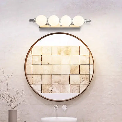 Round mirror with dark wood frame and beige textured tile mosaic reflecting bathroom wall paired with decorbites bubble ball wall sconces