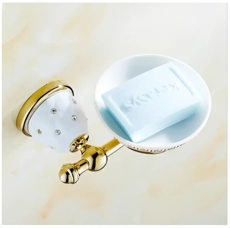 Gold-finished bathroom soap dish with white ceramic bowl and light blue soap in chrome and gold decorbites bathroom hardware set