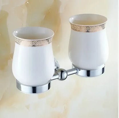 White ceramic toothbrush holders with gold greek key pattern trim and chrome mounting brackets in decorbites bathroom hardware set