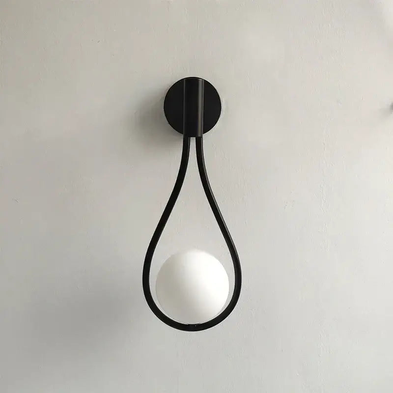 Black metal teardrop wall sconce with white glass ball for bedroom featuring decorbites black glass design