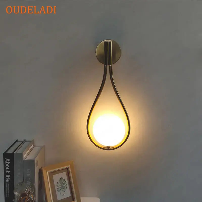 Chrome teardrop wall sconce with brass finish and warm glowing light featuring a white glass ball for bedroom decorbites black glass ball alternative