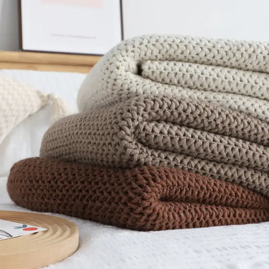 Stack of three chunky knitted leisure blanket throws in cream taupe and brown for bedroom and living room decorbites decor