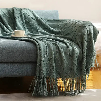A cozy knitted sofa blanket in moss green with a diamond pattern and fringe for living room decorbites comfort
