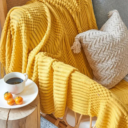 Vibrant yellow chunky ribbed and bobble knit sofa blanket draped on chair for cozy knitted sofa decorbites comfort