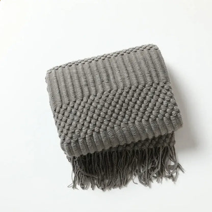 Gray chunky ribbed neutral knitted sofa blanket with fringe detailing for decorbites cozy knitted living room comfort