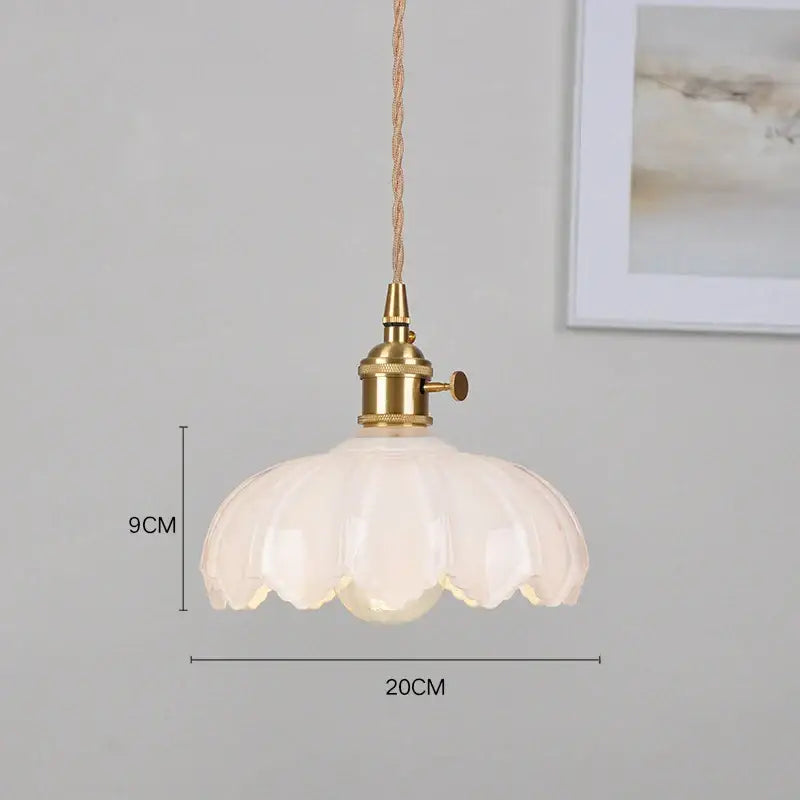 Classic glass white pendant light with brass hardware and fluted petal-like shade ideal for dining room lighting
