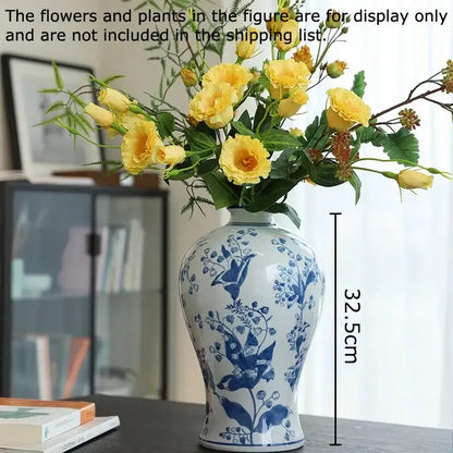 A white porcelain vase with intricate blue floral and bird patterns holding yellow roses for decorbites blue decor