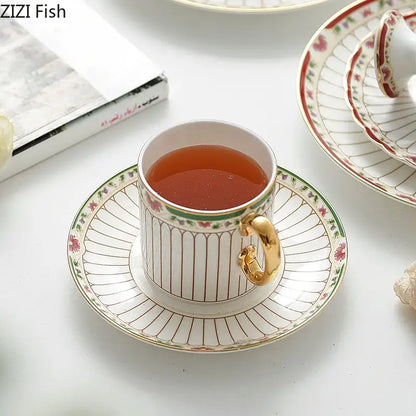 Classical gold-striped ceramic cup and saucer set in white porcelain with gold handle and pink floral rim design
