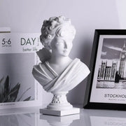 Classical white cupid statue plaster sculpture of a woman with curly hair on an ornate pedestal for living room decor