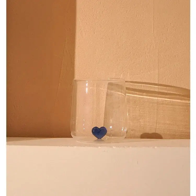 Clear glass heart tumbler mug with a glossy blue decorbites 3d heart ornament at the base for kitchen glassware gift