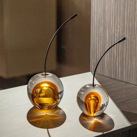 Two translucent glass cherry sculpture ornaments with golden interiors and black stems for living room decorbites crystal cherry display