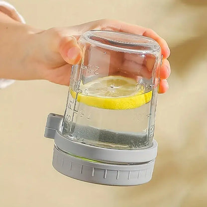 Clear borosilicate drinking glass measuring cup with gray lid and engraved volume markings in us fluid ounces