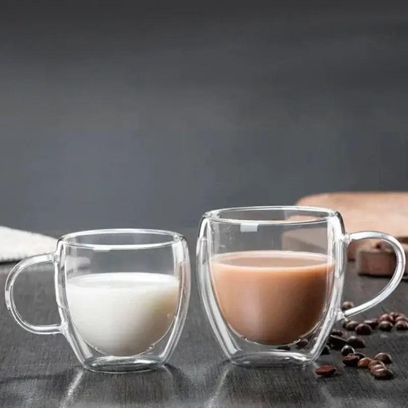 Two clear double wall high borosilicate glass mugs with milk and brown beverage for coffee or dining use