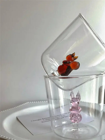 A translucent pink glass cactus bunny figurine with black bead eyes inside a clear glass cup decorbites cactus bunny