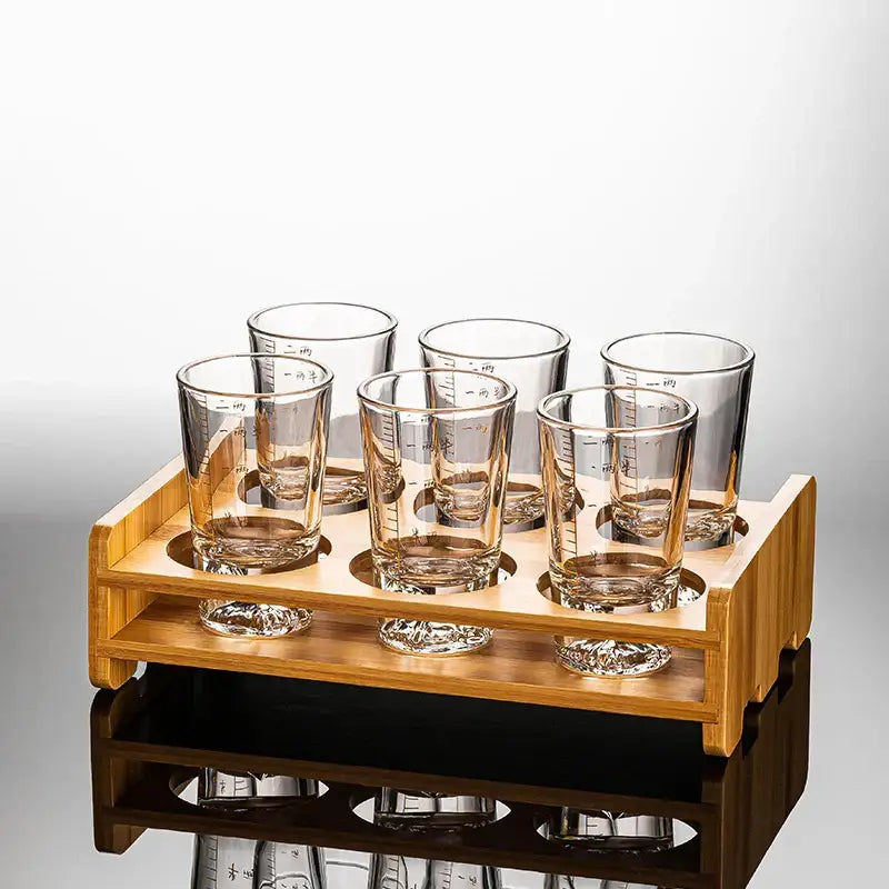Set of six clear glass liquor cups with measurement markings in a light wood serving tray for decorbites clear glass dining room use
