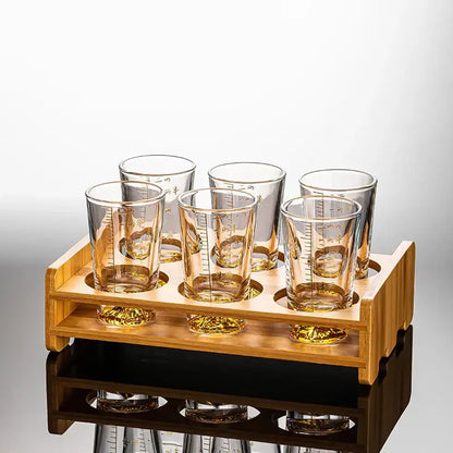 Set of six amber-tinted clear glass liquor shot glasses with measurement markings in a light wood tray for decorbites clear glass