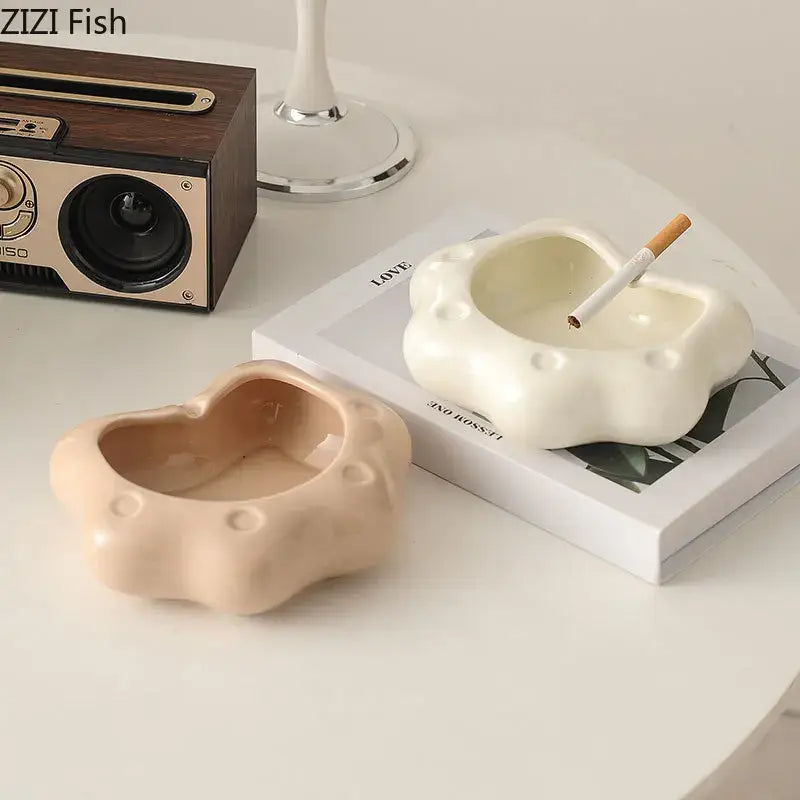 Cream-colored cat paw porcelain ashtray with cloud-like texture and circular indentations for living room decorbites cat paw gift