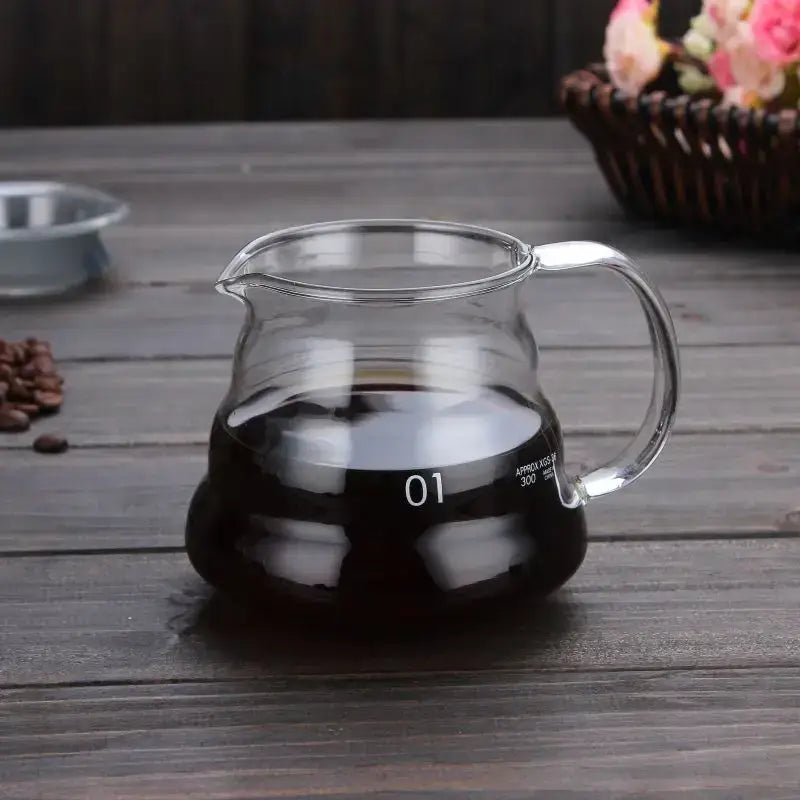 Clear glass coffee kettle with curved handle and spout filled with dark brewed coffee decorbites cloud shaped design