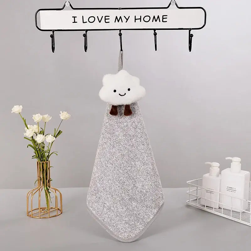A plush decorbites cloudy day hand towel with white cloud shape brown bow tie and textured silver-gray fabric body