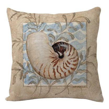 Beige linen decorbites coastal cushion featuring a nautilus shell illustration with blue waves and gray-green foliage
