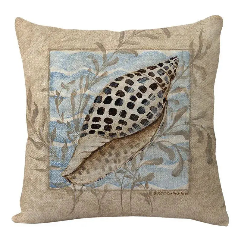 Beige decorbites coastal cushion cover featuring black-spotted seashell embroidery on blue ocean seaweed backdrop