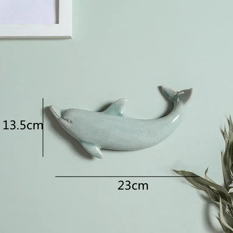 A sleek light blue ceramic dolphin fish ocean wall decoration with glossy crackle glaze for children’s room decorbites wall decoration
