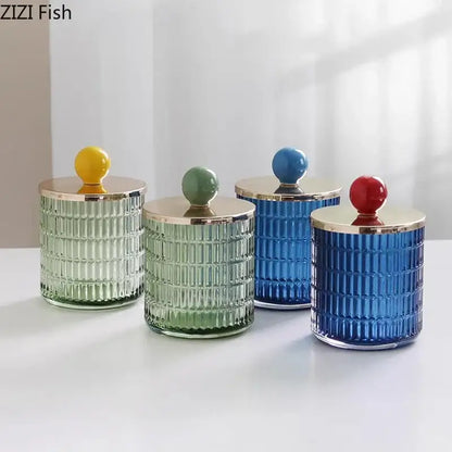 Set of four colorful decorbites glass tea storage jars with ribbed bodies and gold-toned glass tea canister lids