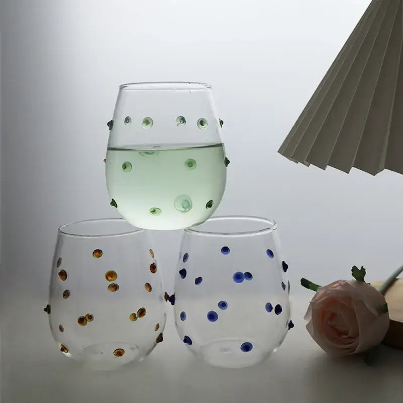 Clear stemless wine glasses with colorful gold blue and green glass wave dots for dining room use