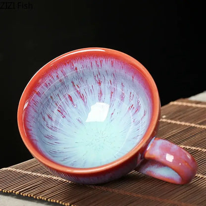 A colorful glazed porcelain tea cup and saucer set with a glossy gradient from deep red to light blue and reddish-brown streaks