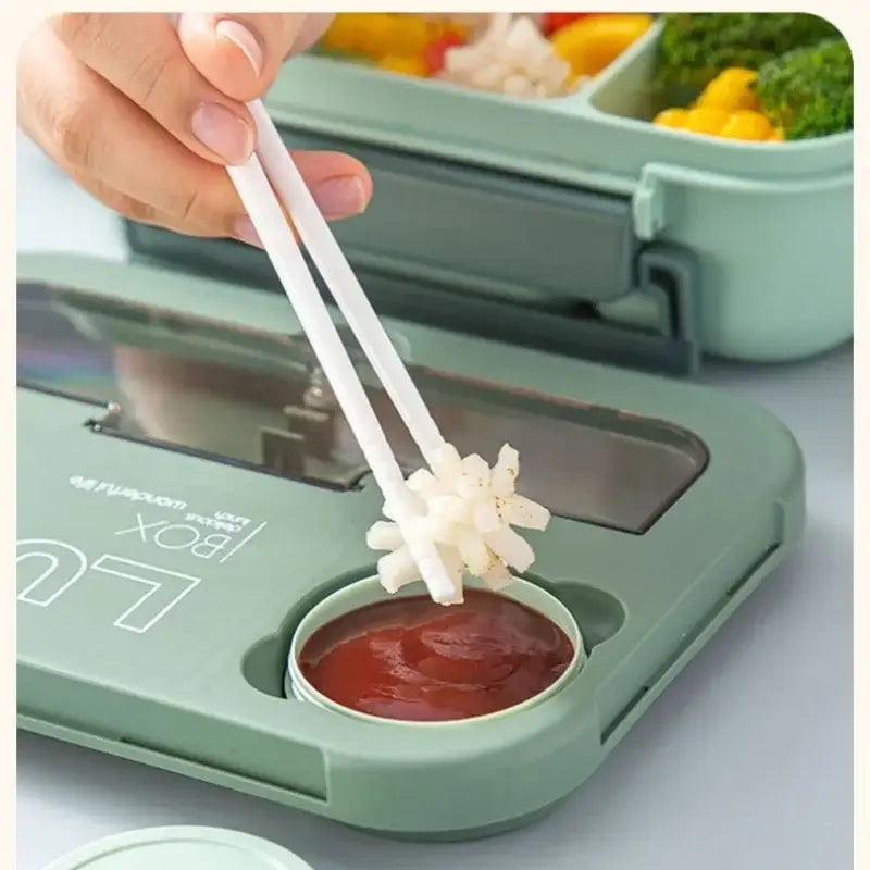 White plastic chopsticks with star grip dipping food into ketchup paired with colorful plastic lunch box set