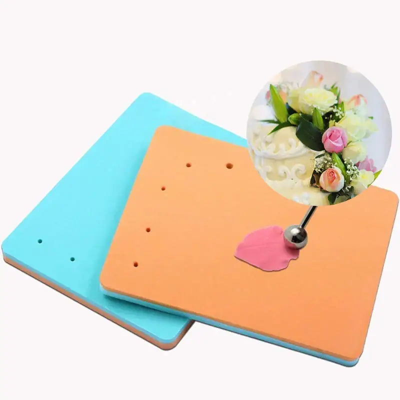 Colorful orange and blue silicone cake shaping mat with a pink petal pressed by a metal tool for fondant embossing