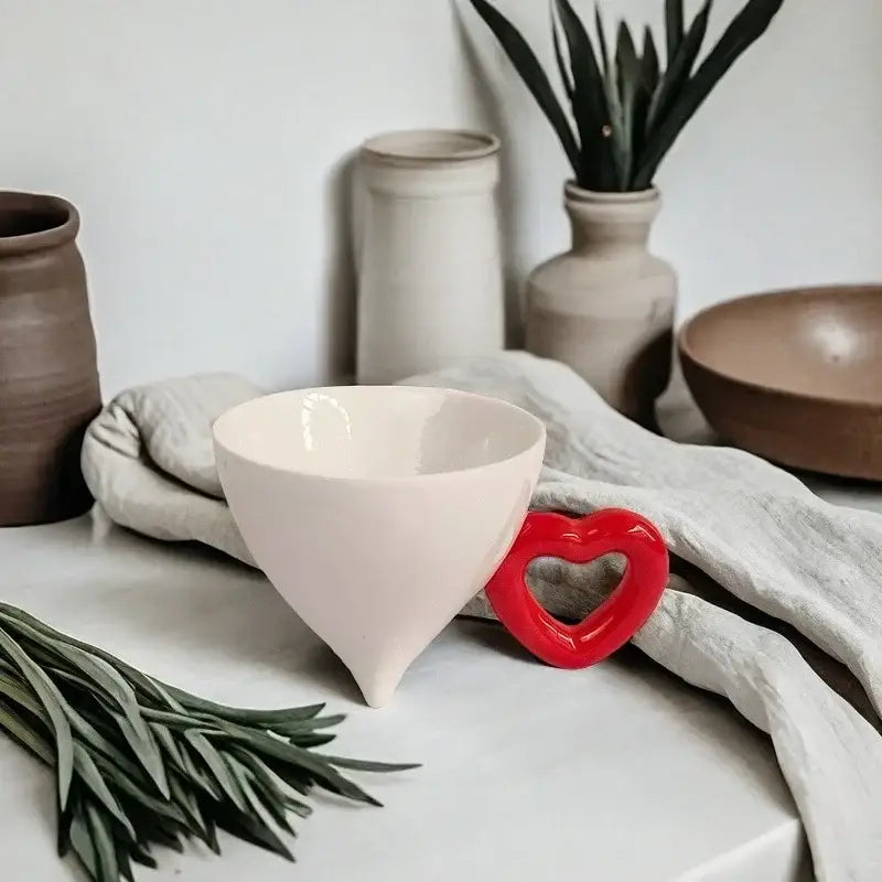 A blush-pink conical ceramic coffee mug with a tapered design and smooth glossy finish from decorbites heart ceramic collection