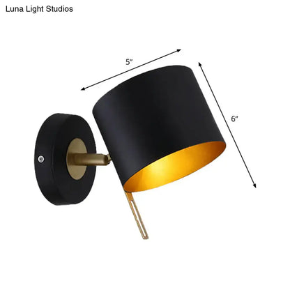 Contemporary black and gold metal drum wall sconce with brass accents for bedroom lighting