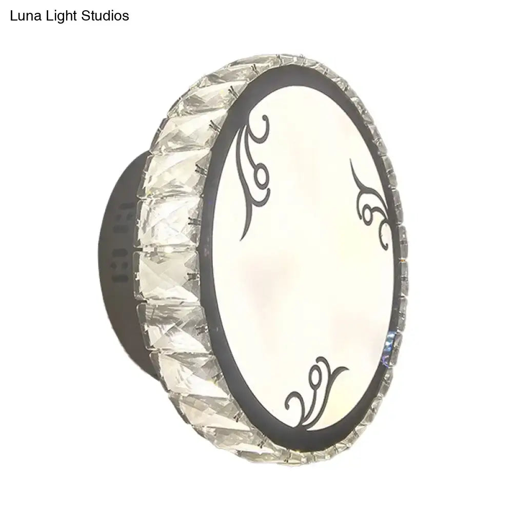 Contemporary black circular wall light with clear crystal trim and oval white diffuser featuring black swirling patterns