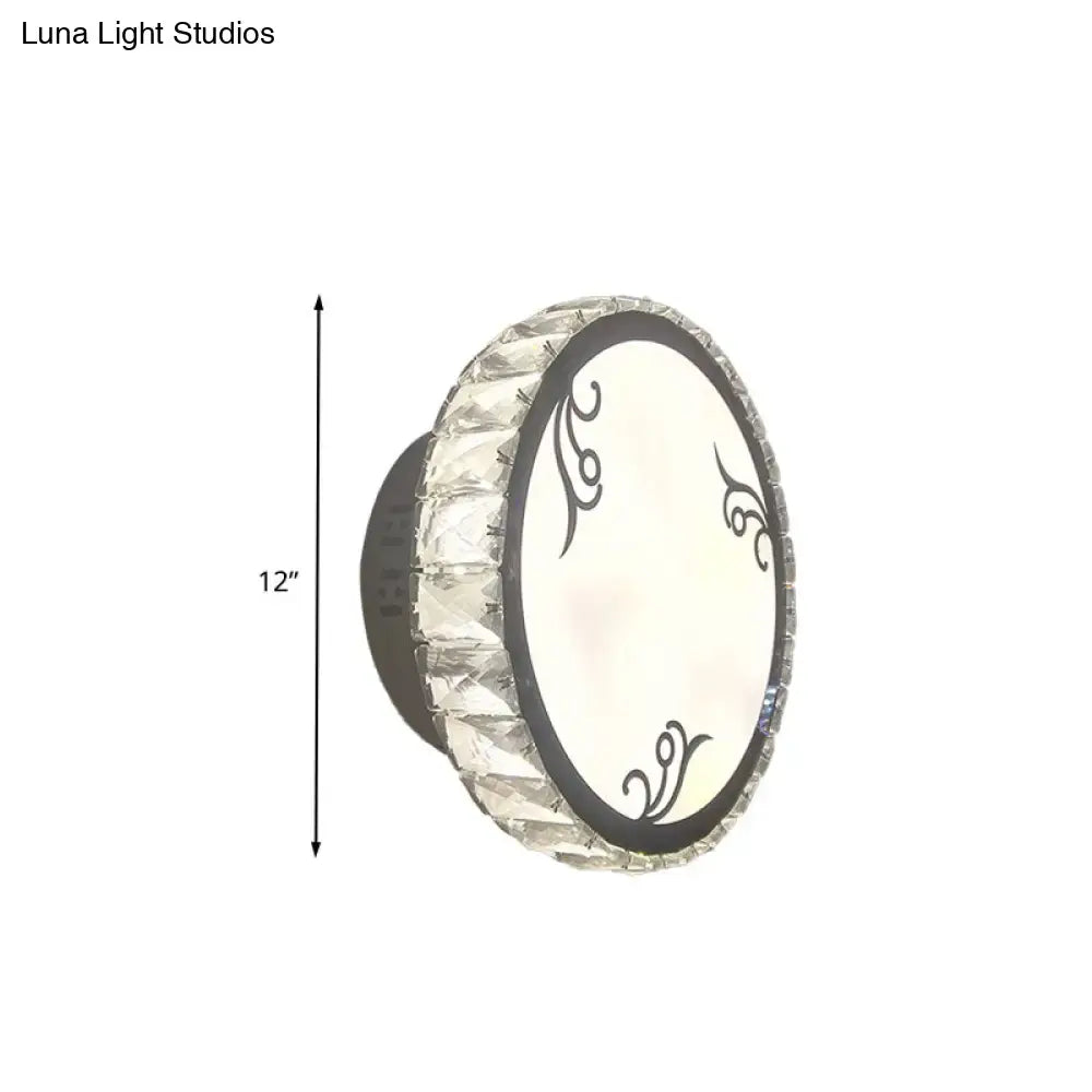 Contemporary black circular wall light with clear crystal trim and decorative swirl patterns on white diffuser for bedroom