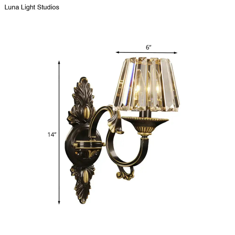 Contemporary black and gold crystal prism wall light featuring an antique brass and black ornate wall mounted sconce